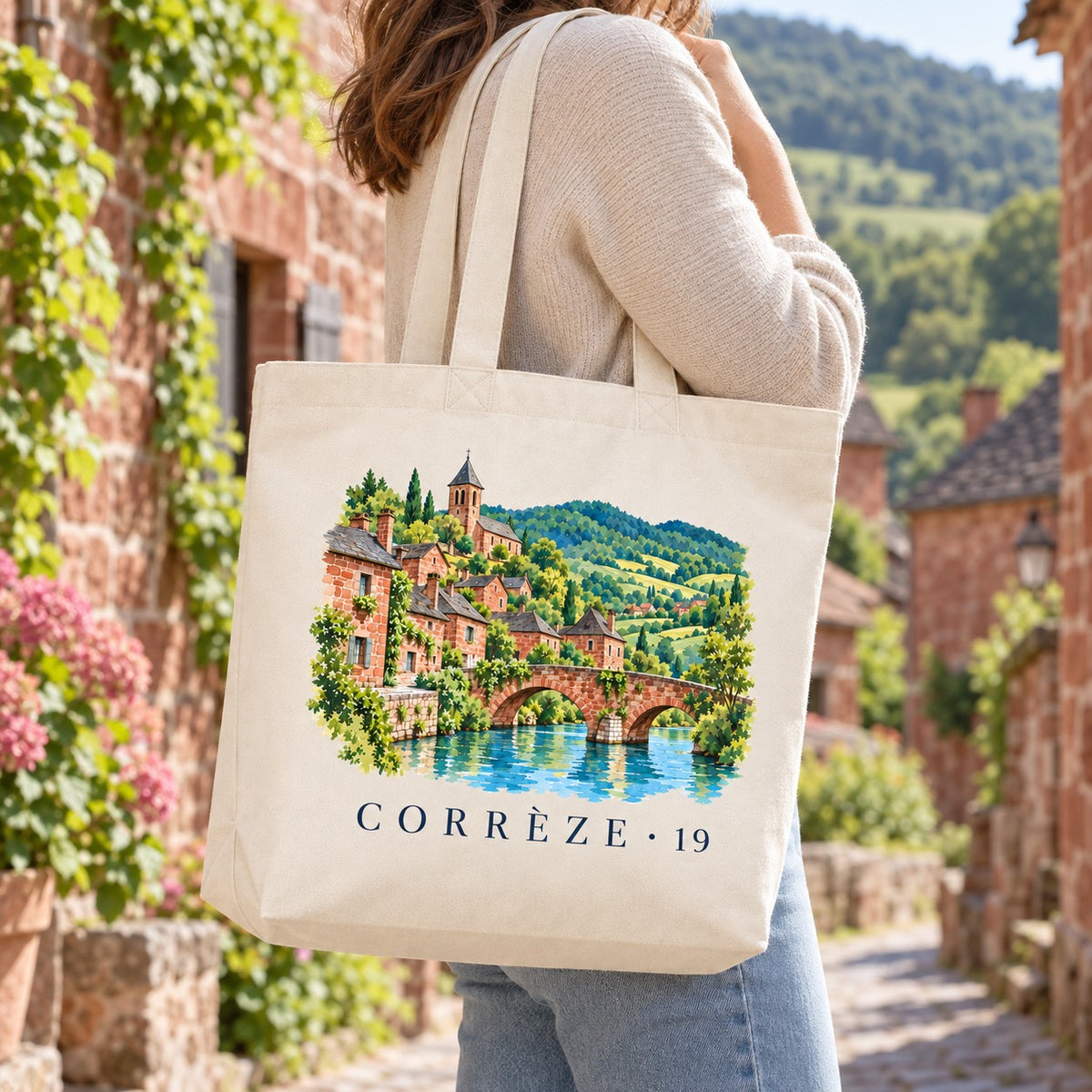 Tote bag Corrèze (19) Premium porté à l'épaule dans une ruelle de grès rouge