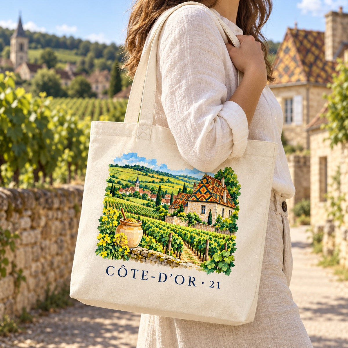 Tote bag Côte-d'Or (21) Premium porté à l'épaule dans une ruelle de village viticole