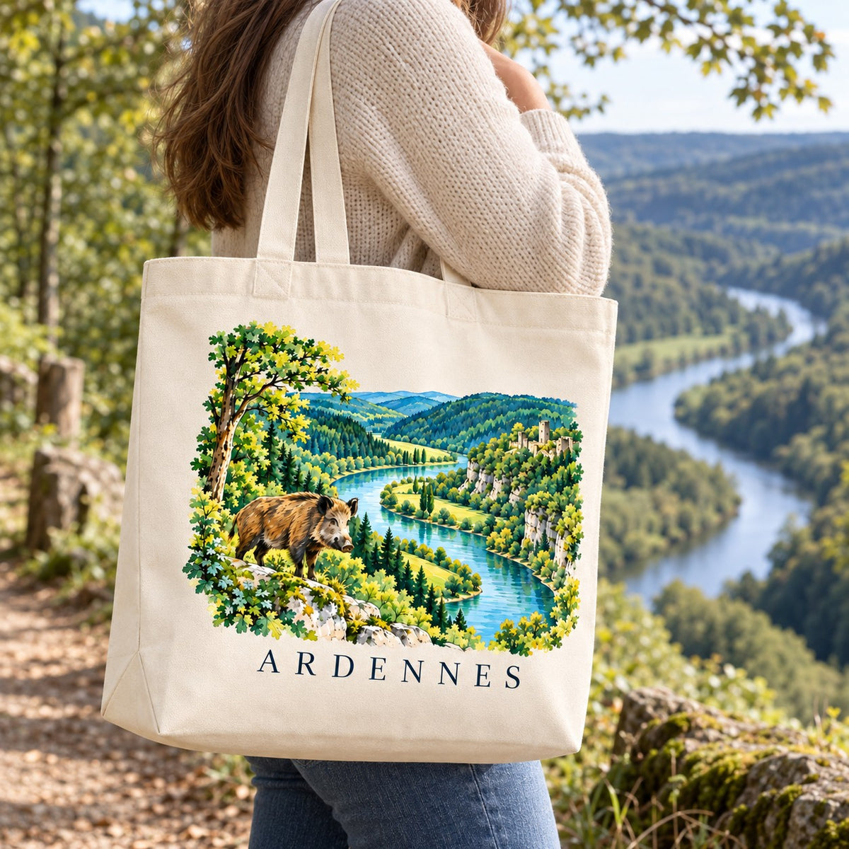 Tote bag Ardennes Premium porté à l'épaule sur un belvédère face aux méandres de la rivière