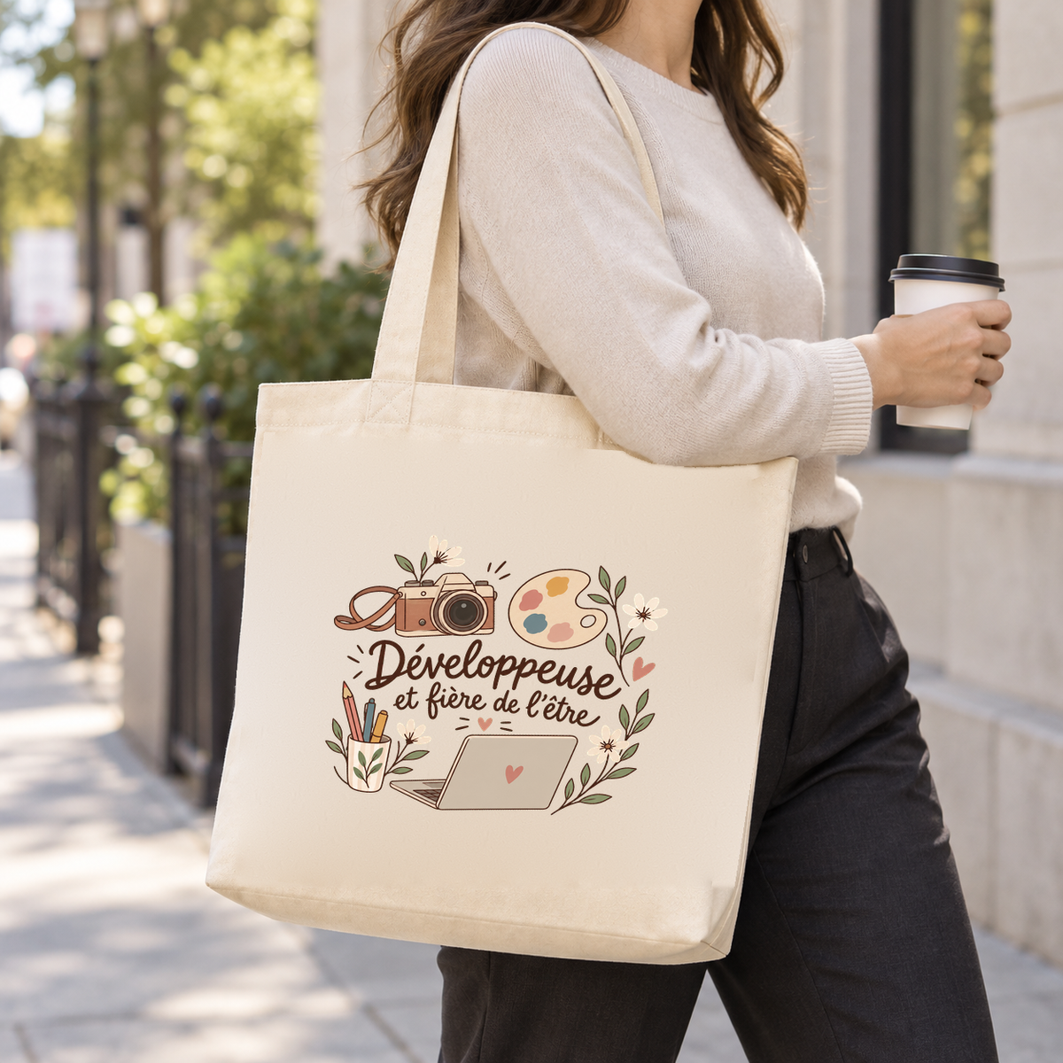 Tote bag développeuse « Développeuse et fière de l'être » Premium porté à l'épaule dans la rue, un café à la main
