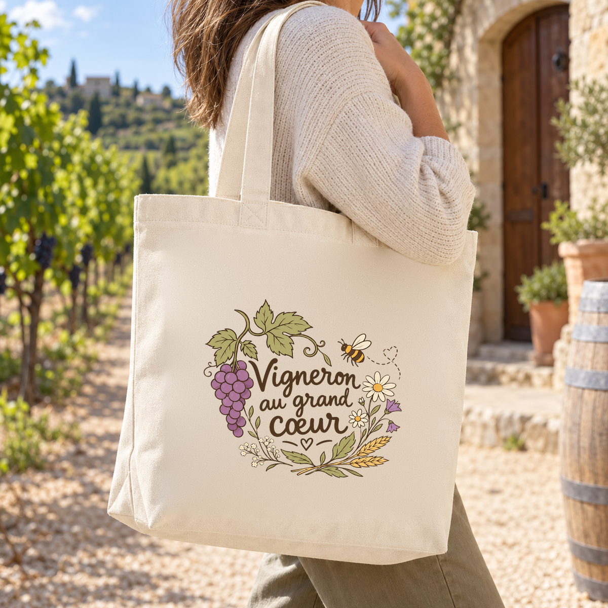 Tote bag vigneron « Vigneron au grand cœur » Premium porté à l'épaule dans la cour d'un domaine viticole