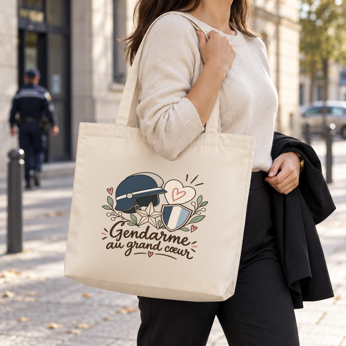 Tote bag gendarme « Gendarme au grand cœur » Premium porté à l'épaule dans la rue, une veste sur le bras