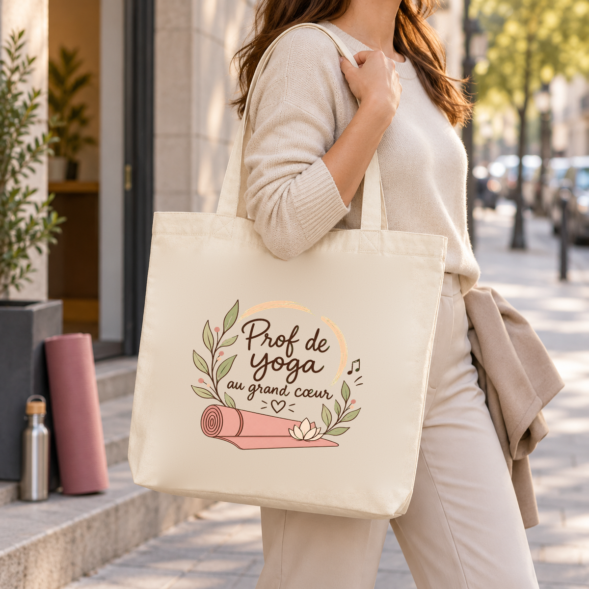 Tote bag prof de yoga « Prof de yoga au grand cœur » Premium porté à l'épaule dans la rue, un tapis de yoga sous le bras