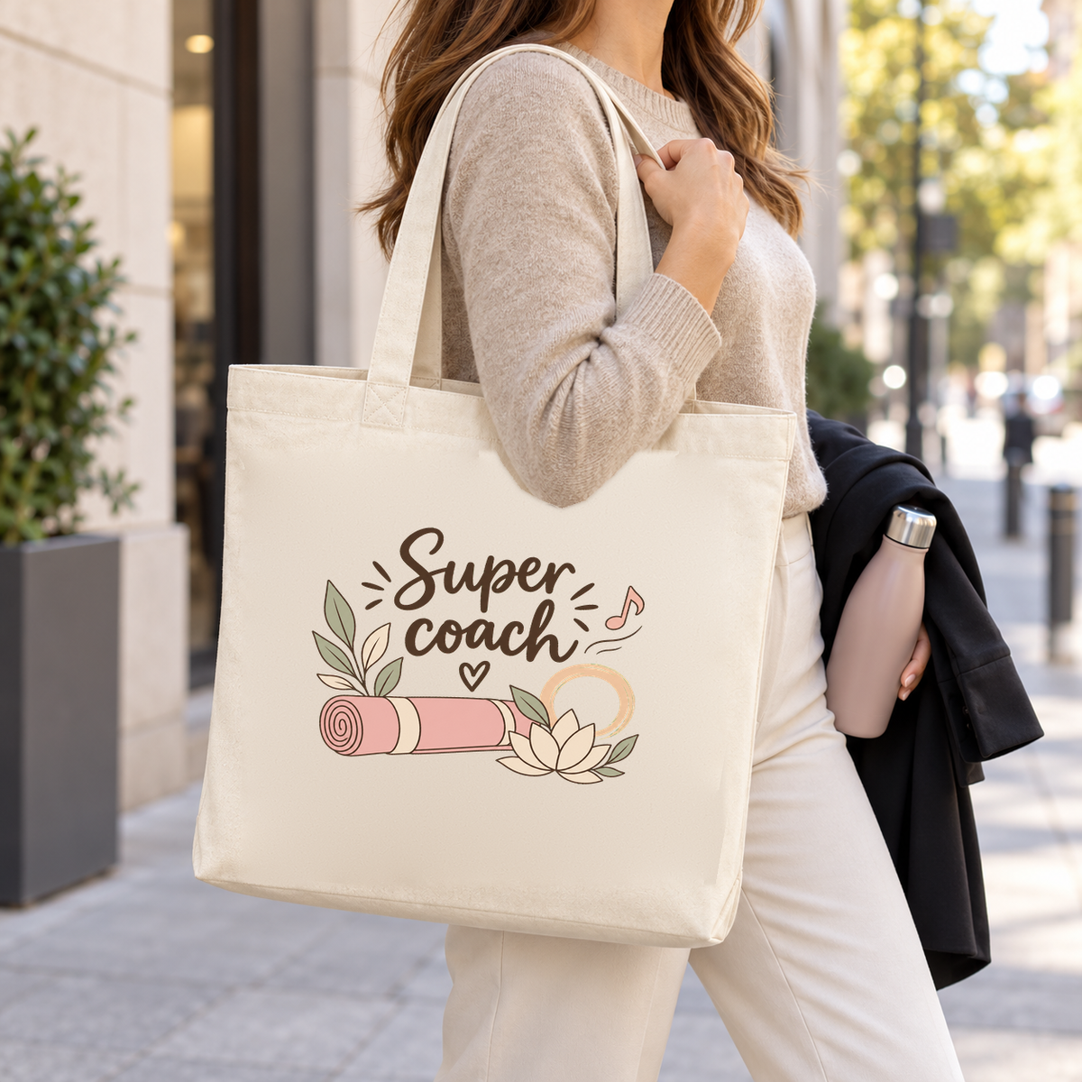 Tote bag coach sportif « Super coach » Premium porté à l'épaule dans la rue, une gourde à la main