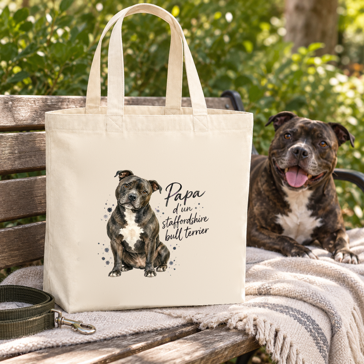 Tote bag staffordshire bull terrier « Papa d'un staffordshire bull terrier » Premium posé sur un banc à côté d'un staffie, sur un plaid