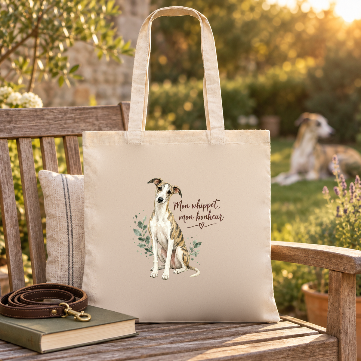 Tote bag whippet « Mon whippet, mon bonheur » Essentiel posé sur un banc de jardin, à côté d'un livre et d'une laisse, un whippet dans l'herbe