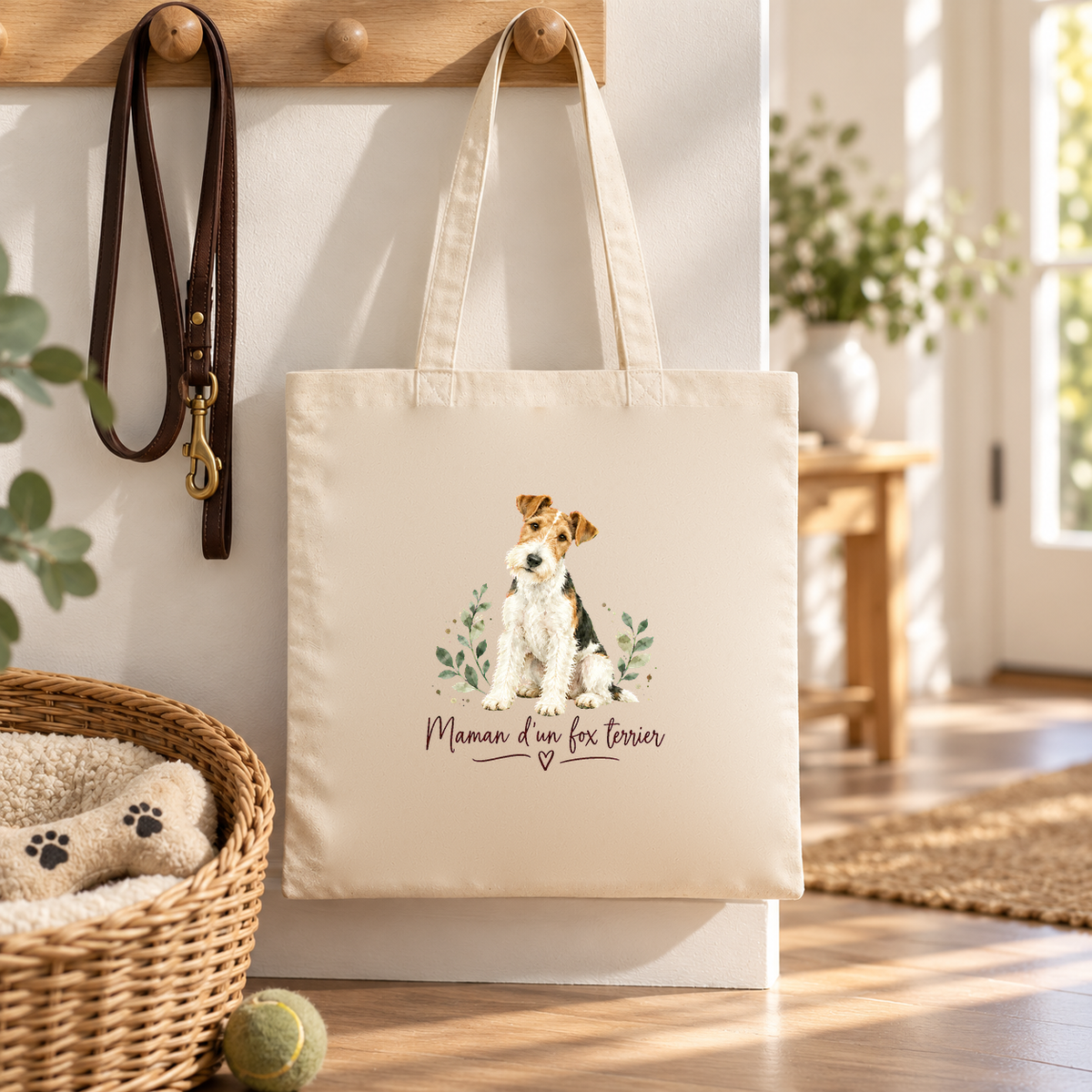 Tote bag fox terrier « Maman d'un fox terrier » Essentiel suspendu à une patère dans l'entrée, à côté d'une laisse et d'un panier pour chien