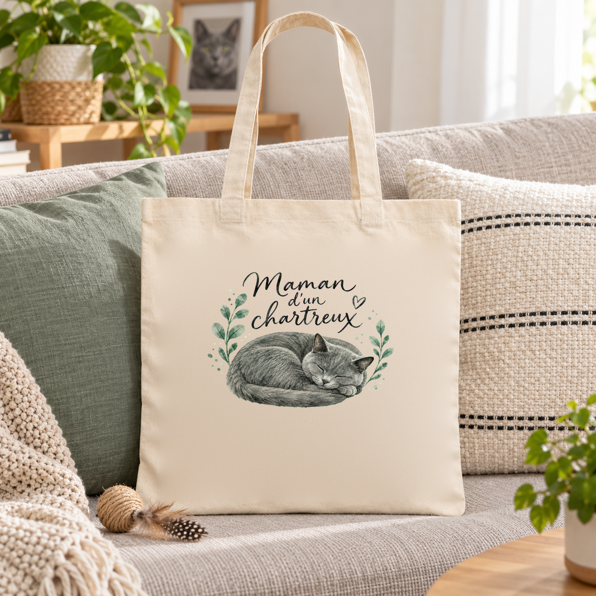 Tote bag chartreux « Maman d'un chartreux » Essentiel posé sur un canapé entre des coussins