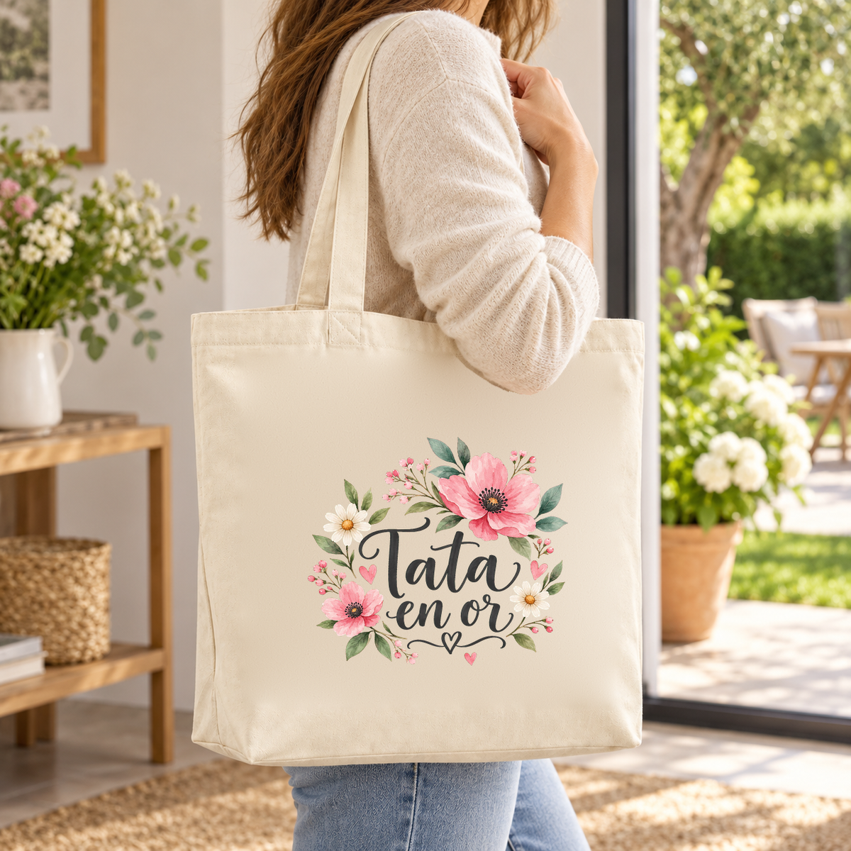 Tote bag tata « Tata en or » Premium porté à l'épaule sur une terrasse fleurie, lors d'une promenade au jardin