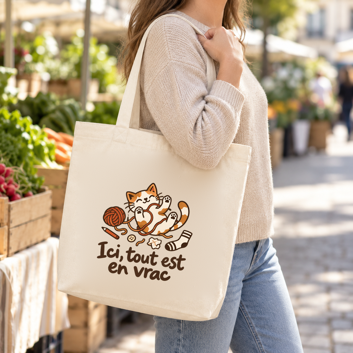 Tote bag « Ici, tout est en vrac » Premium porté à l'épaule dans une rue commerçante