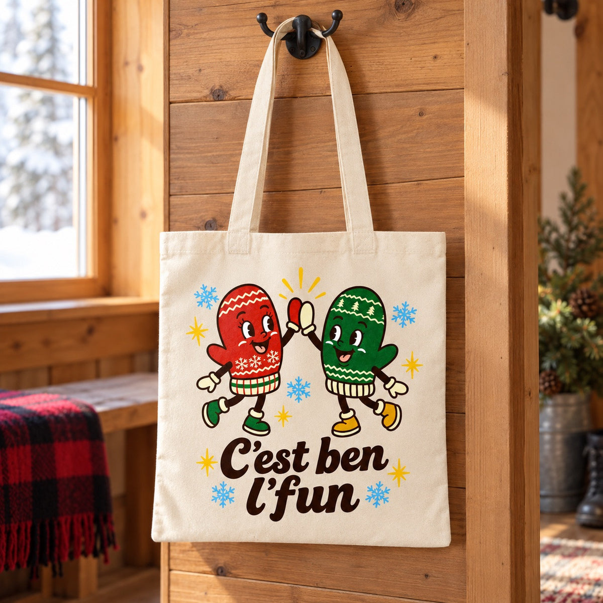 Tote bag « C'est ben l'fun » Essentiel suspendu à une patère dans une entrée