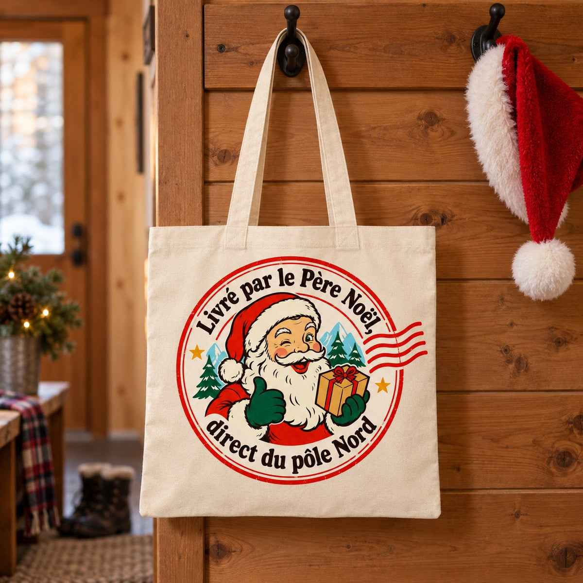 Tote bag « Livré par le Père Noël, direct du pôle Nord » Essentiel suspendu à une patère dans une entrée
