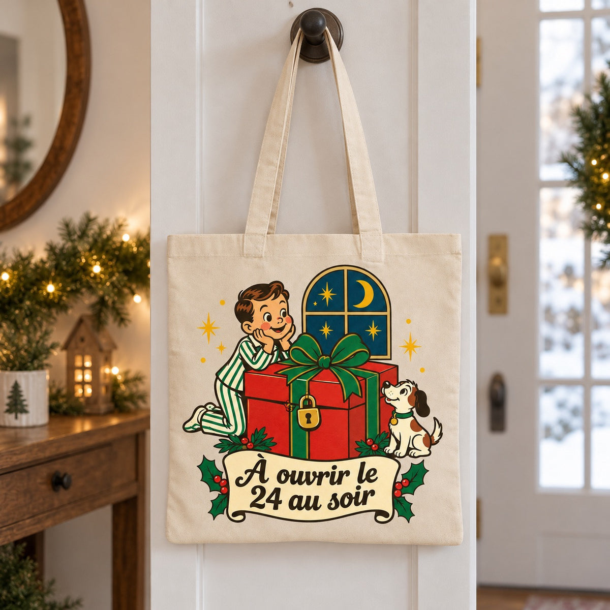 Tote bag « À ouvrir le 24 au soir » Essentiel suspendu à une patère dans une entrée