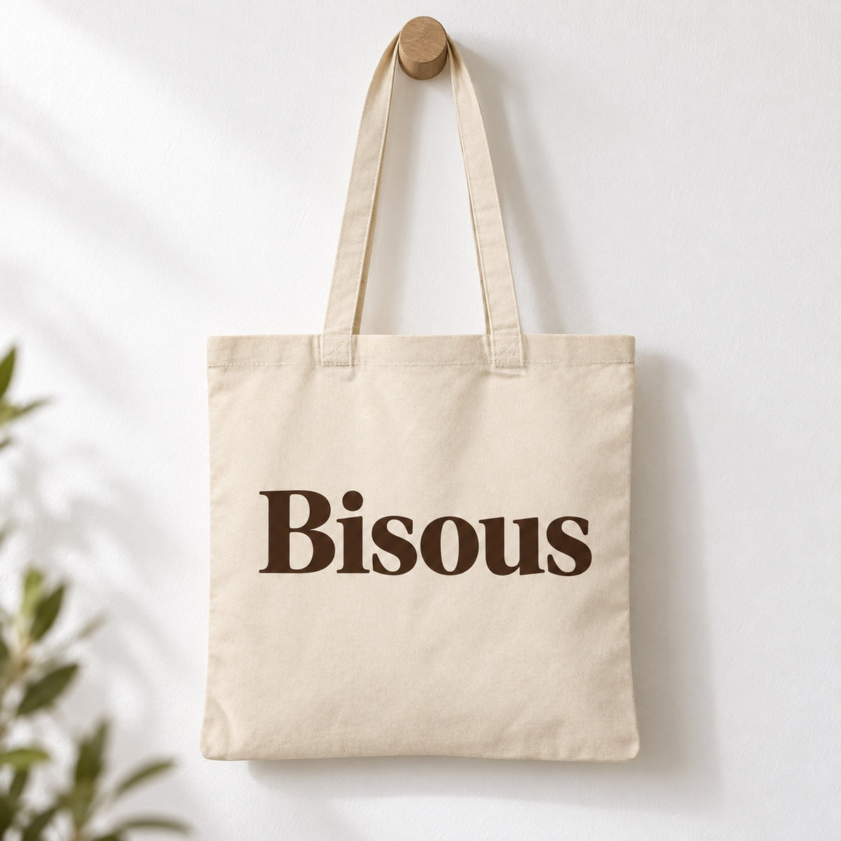 Tote bag « Bisous » Essentiel suspendu à une patère