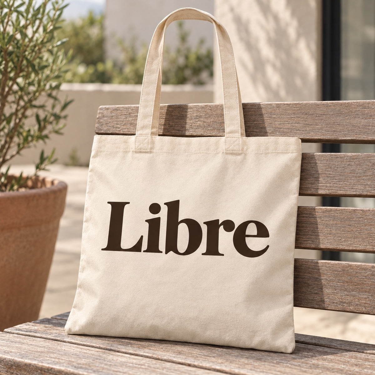 Tote bag « Libre » Essentiel posé contre une chaise dans un intérieur clair