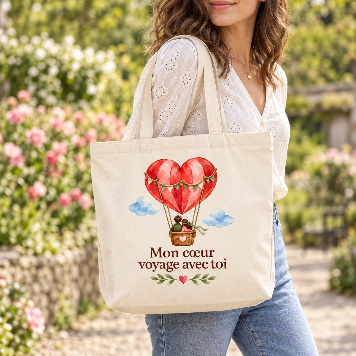 Tote bag « Mon cœur voyage avec toi » Premium porté à l'épaule dans un jardin fleuri