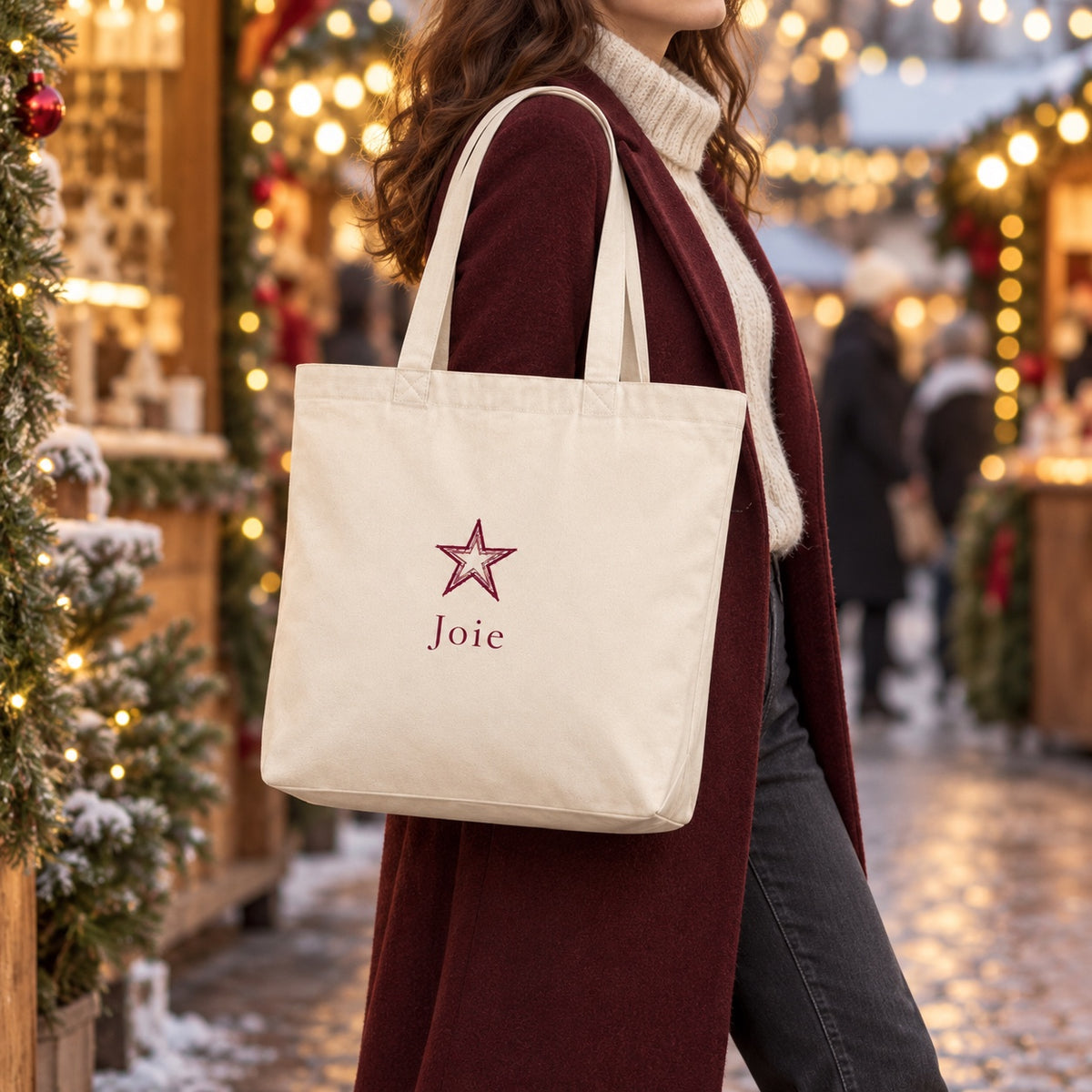 Tote bag de Noël « Joie » Premium porté à l'épaule dans un marché de Noël