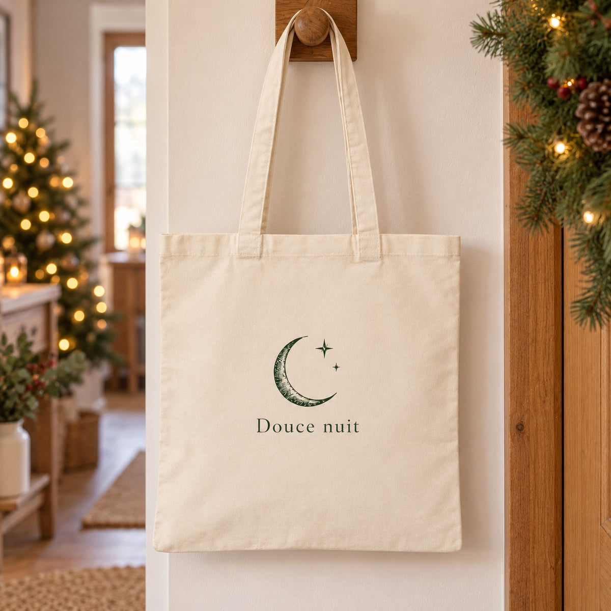 Tote bag de Noël « Douce nuit » Essentiel suspendu à une patère dans une entrée décorée pour Noël