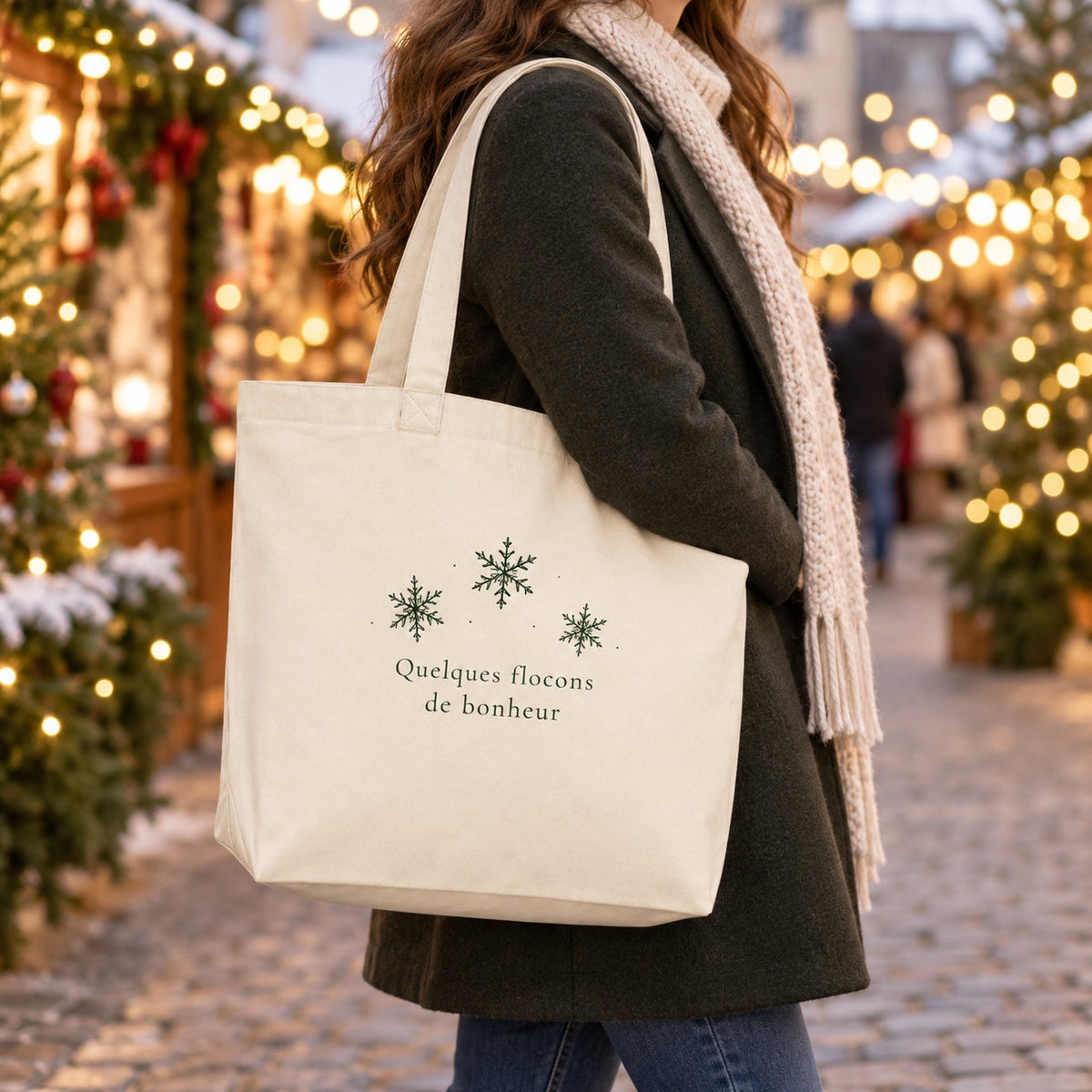 Tote bag de Noël « Quelques flocons de bonheur » Premium porté à l'épaule dans un marché de Noël
