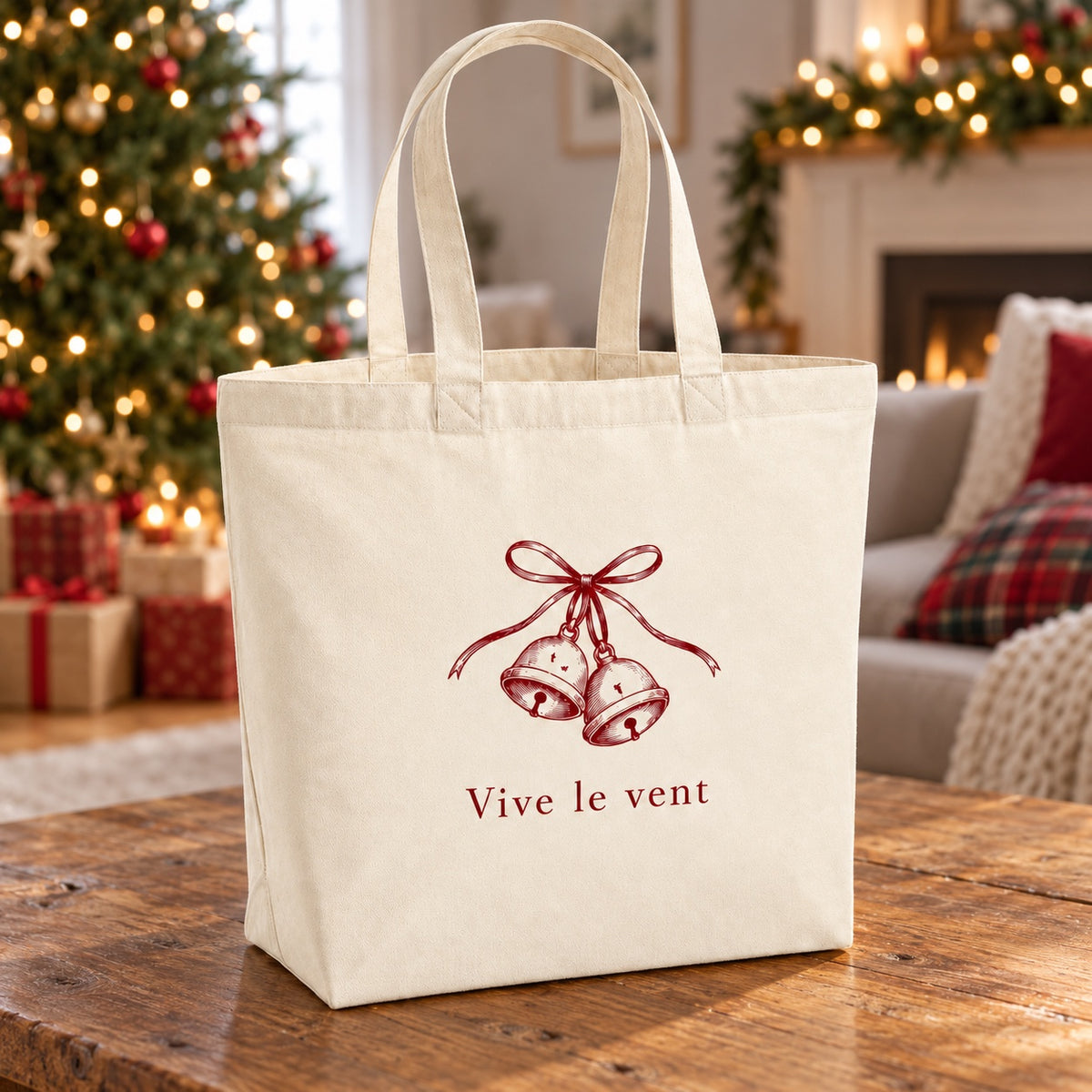 Tote bag de Noël « Vive le vent » Premium posé sur une table de salon devant le sapin