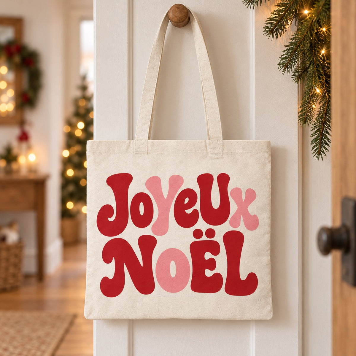 Tote bag de Noël « Joyeux Noël » Essentiel suspendu à une patère dans une entrée décorée pour Noël