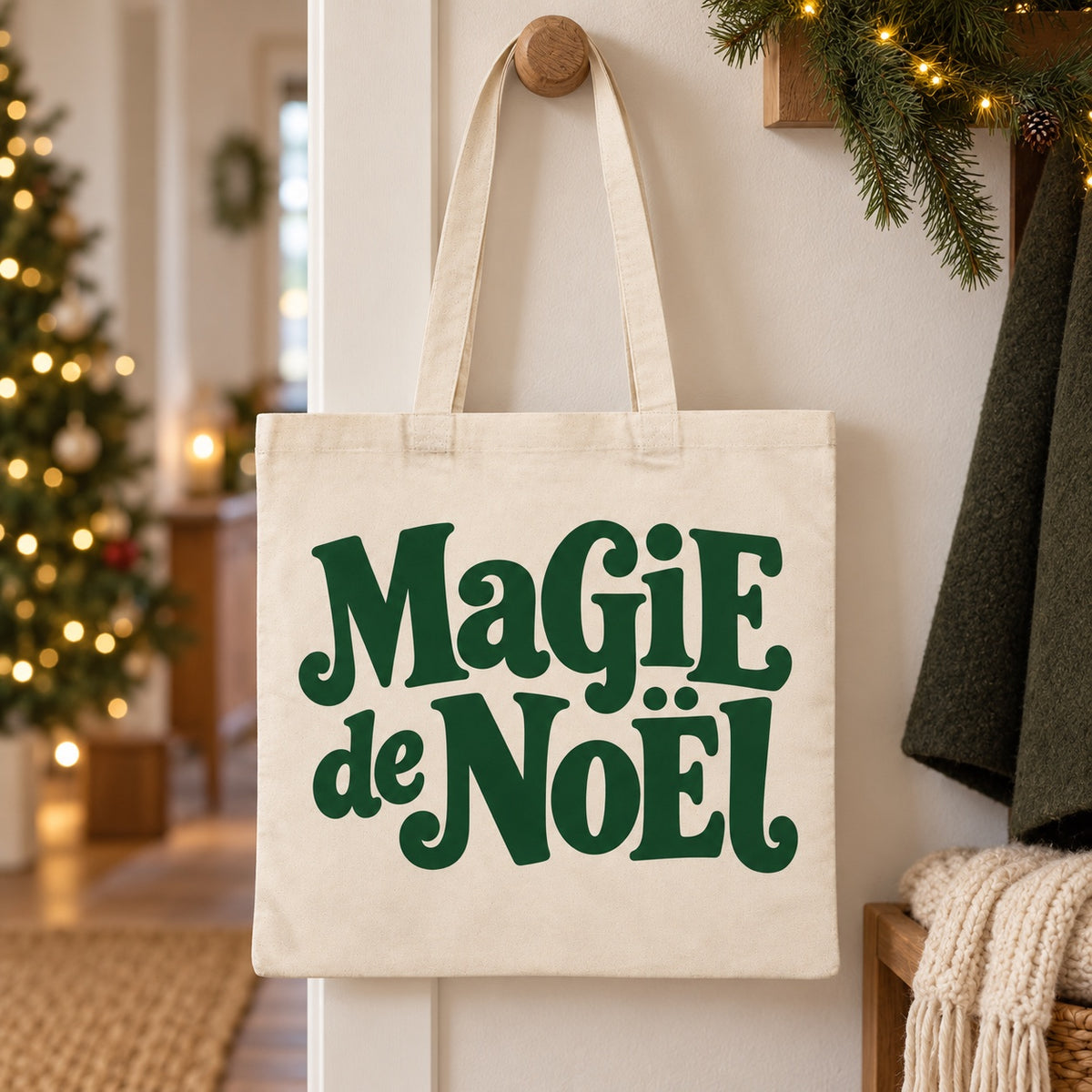Tote bag de Noël « Magie de Noël » Essentiel suspendu à une patère dans une entrée décorée pour Noël