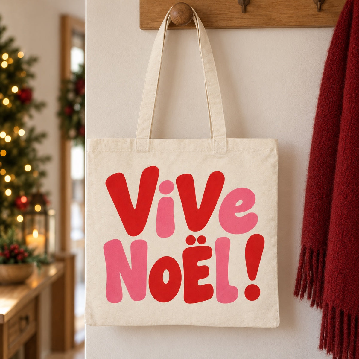 Tote bag de Noël « Vive Noël ! » Essentiel suspendu à une patère dans une entrée décorée pour Noël