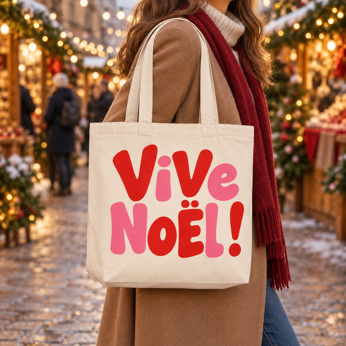 Tote bag de Noël « Vive Noël ! » Premium porté à l'épaule dans un marché de Noël