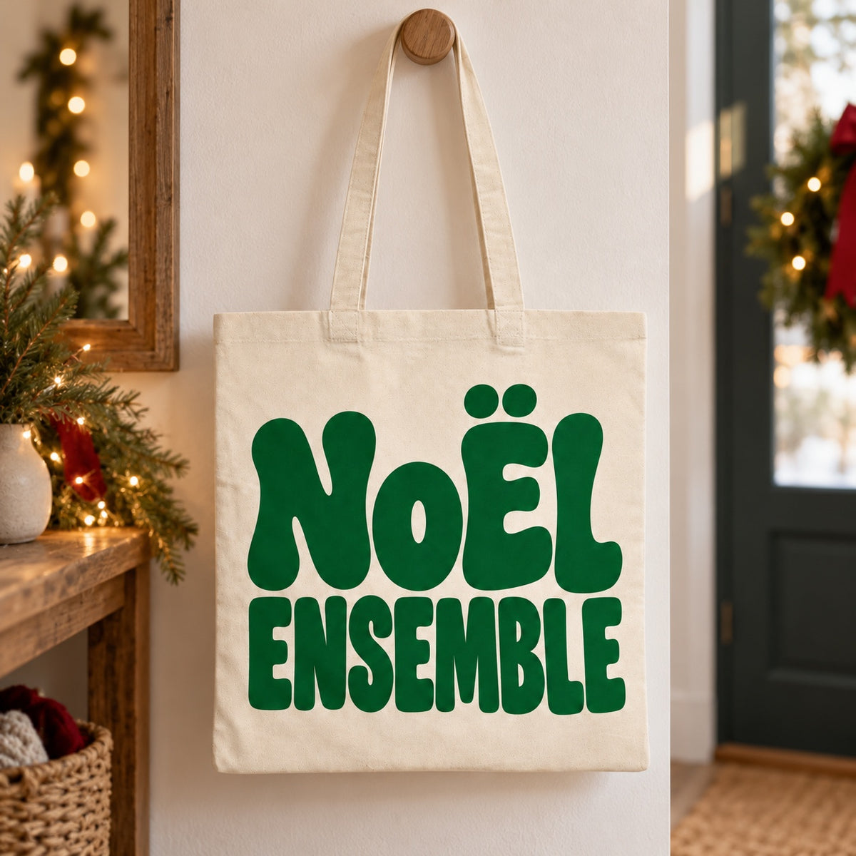Tote bag de Noël « Noël ensemble » Essentiel suspendu à une patère dans une entrée décorée pour Noël