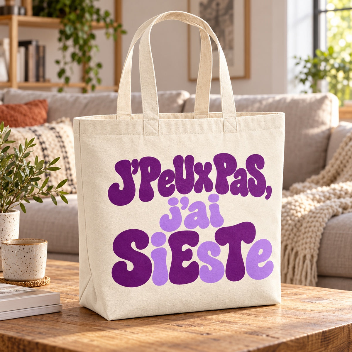Tote bag « J'peux pas, j'ai sieste » Premium posé sur une table basse dans un salon cosy