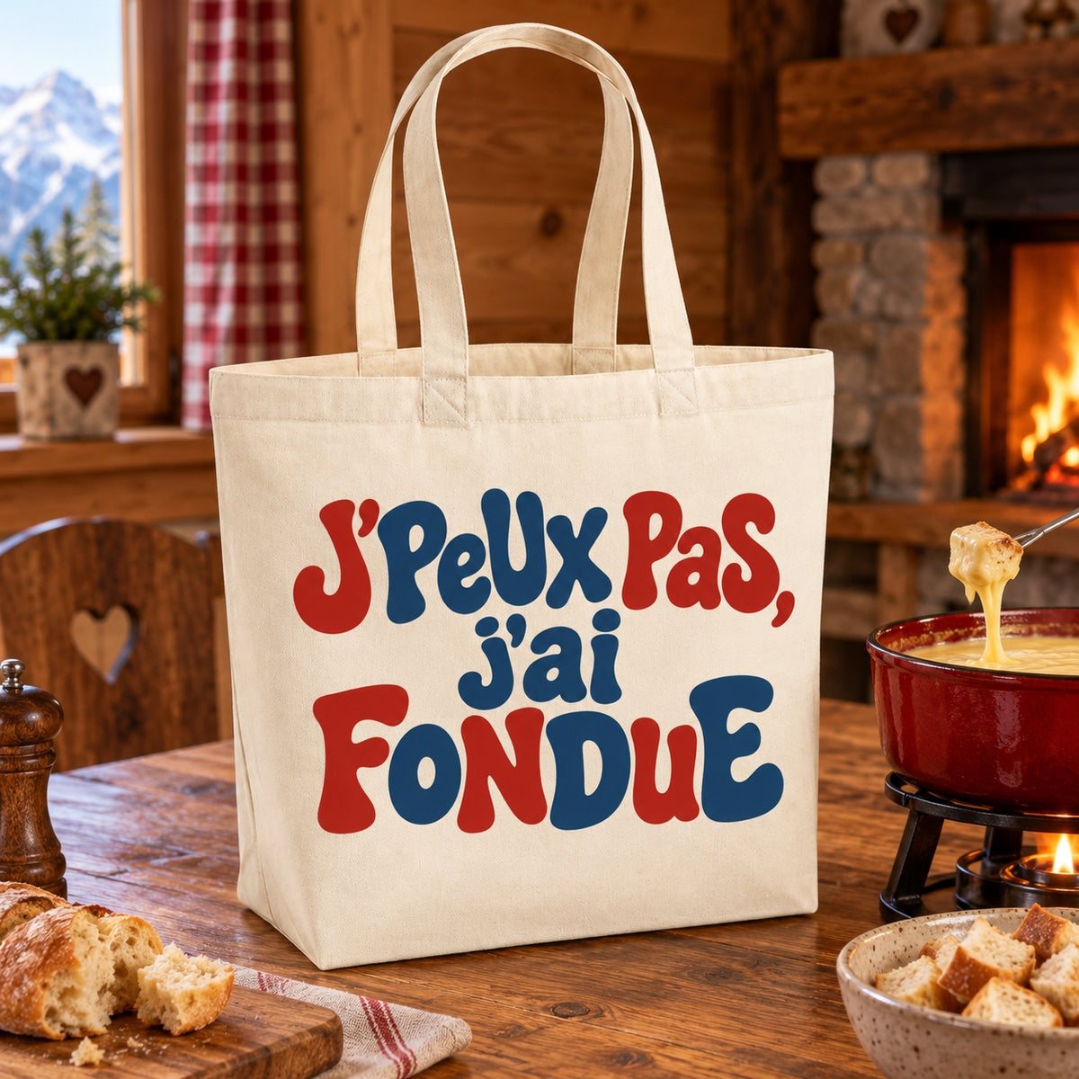 Tote bag « J'peux pas, j'ai fondue » Premium posé sur une table de chalet près d'une fondue