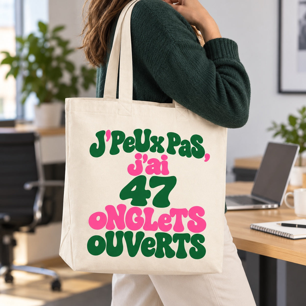 Tote bag « J'peux pas, j'ai 47 onglets ouverts » Premium porté à l'épaule dans un bureau lumineux