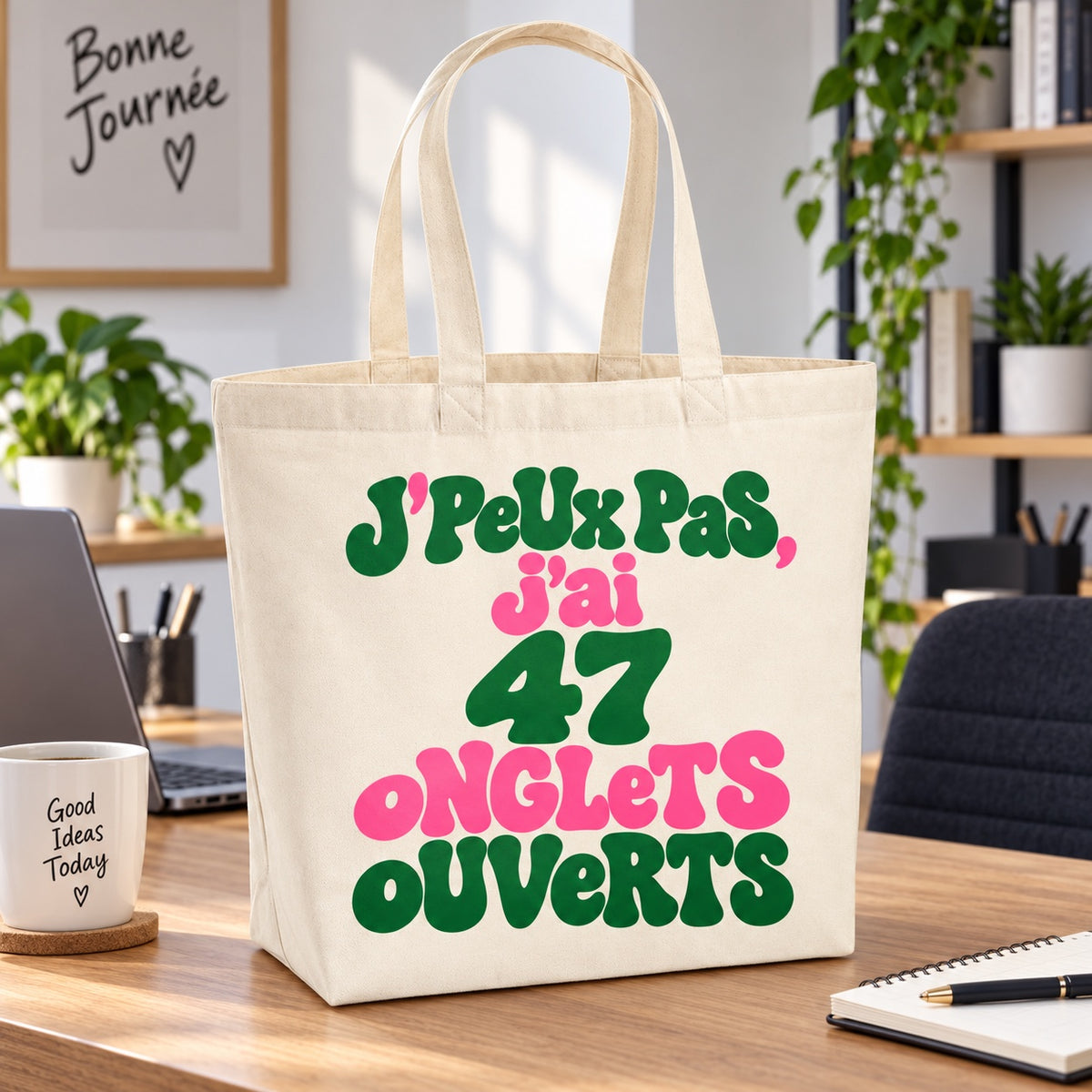 Tote bag « J'peux pas, j'ai 47 onglets ouverts » Premium posé sur un bureau près d'un ordinateur portable