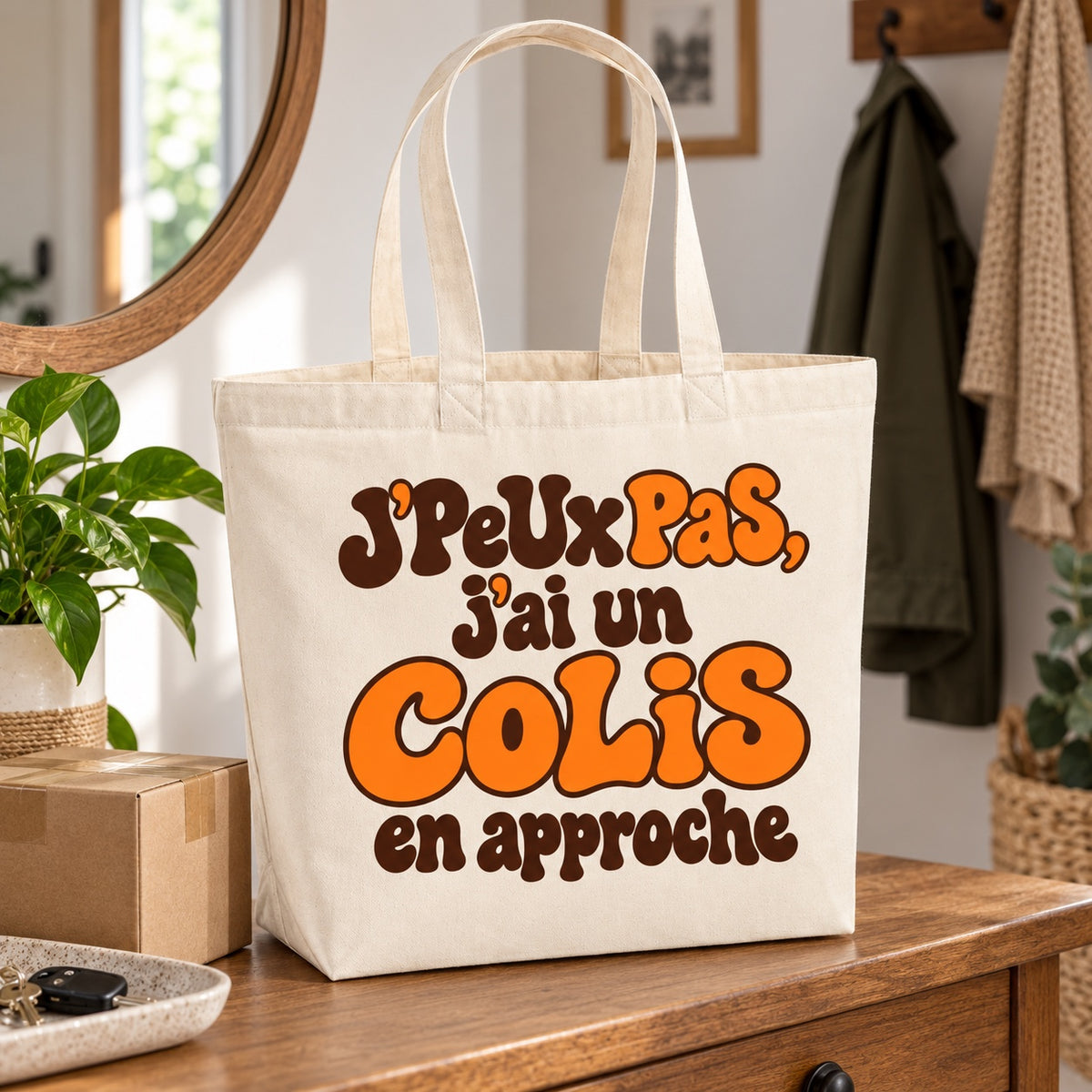 Tote bag « J'peux pas, j'ai un colis en approche » Premium posé sur une console d'entrée près de cartons