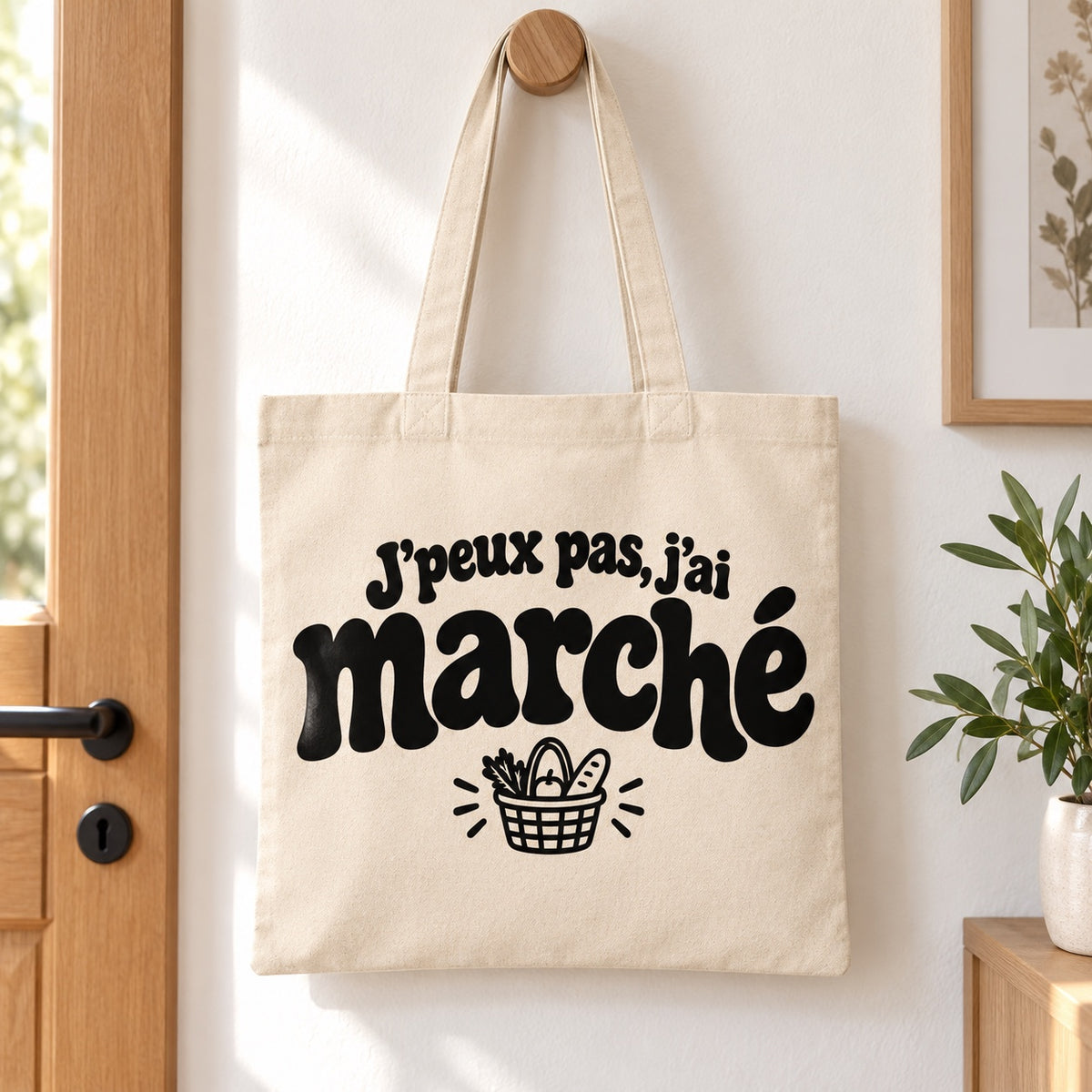 Tote bag « J'peux pas, j'ai marché » Essentiel suspendu à une patère dans une entrée lumineuse