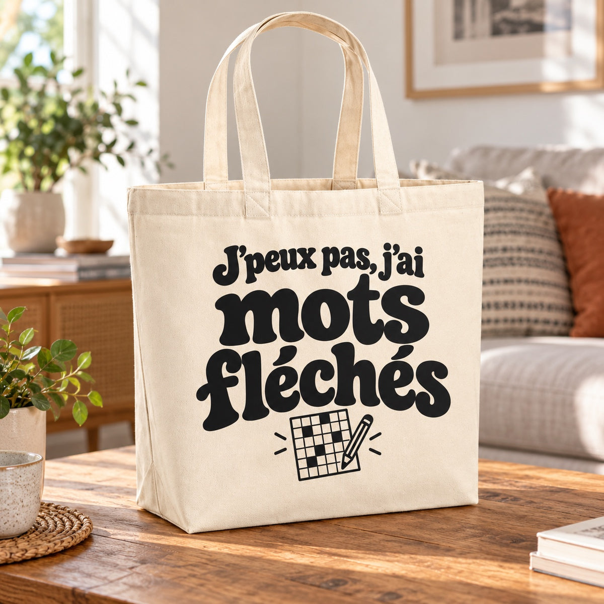 Tote bag « J'peux pas, j'ai mots fléchés » Premium posé sur une table en bois dans un salon lumineux