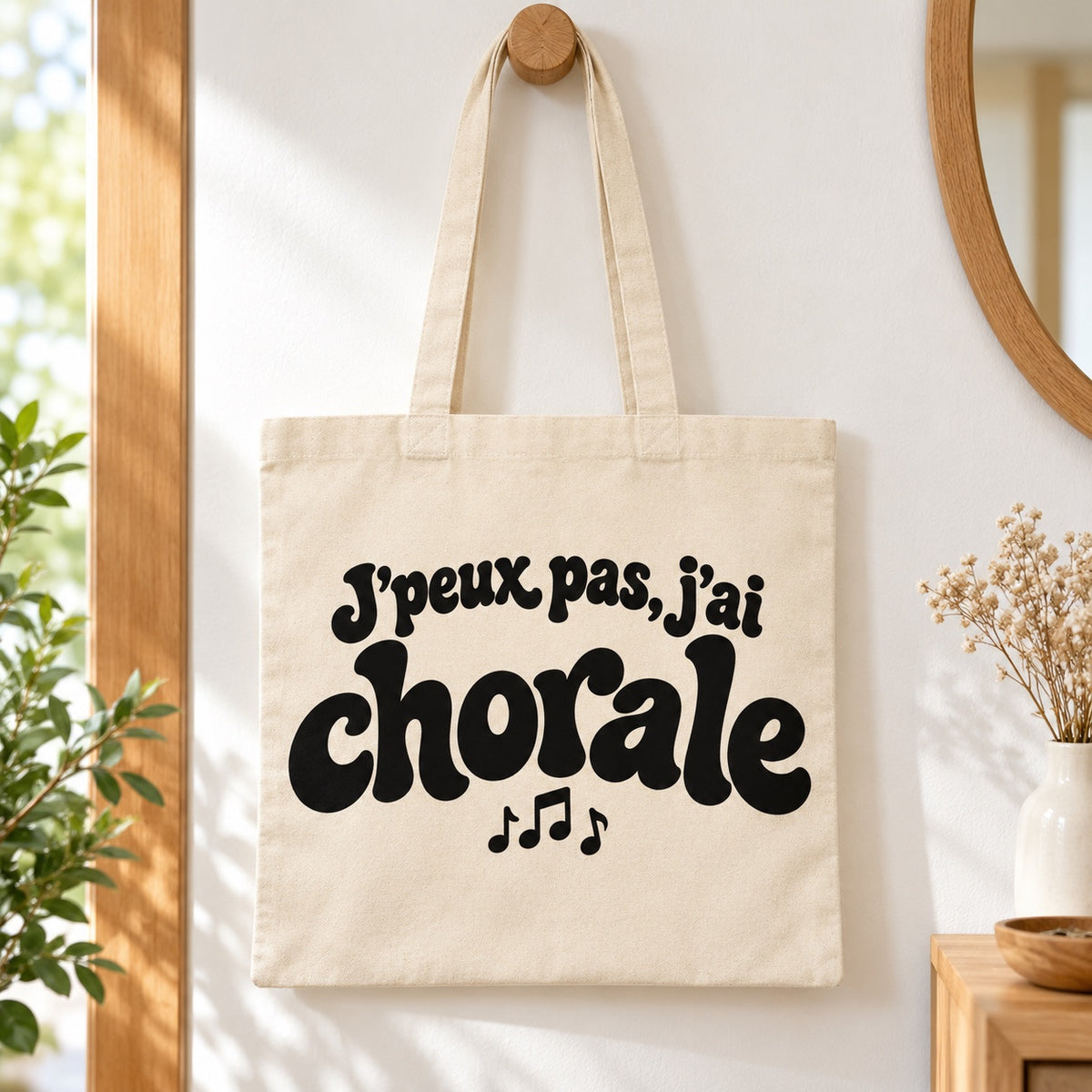 Tote bag « J'peux pas, j'ai chorale » Essentiel suspendu à une patère dans une entrée lumineuse